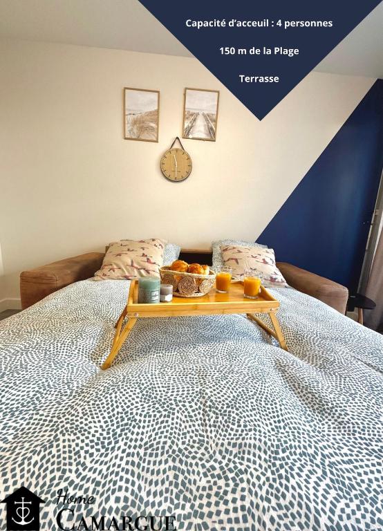 - un plateau avec des oranges et d'autres aliments sur un lit dans l'établissement LE BLUE PACIFIC- 150m de la plage- Terrasse- Wifi, à La Grande Motte