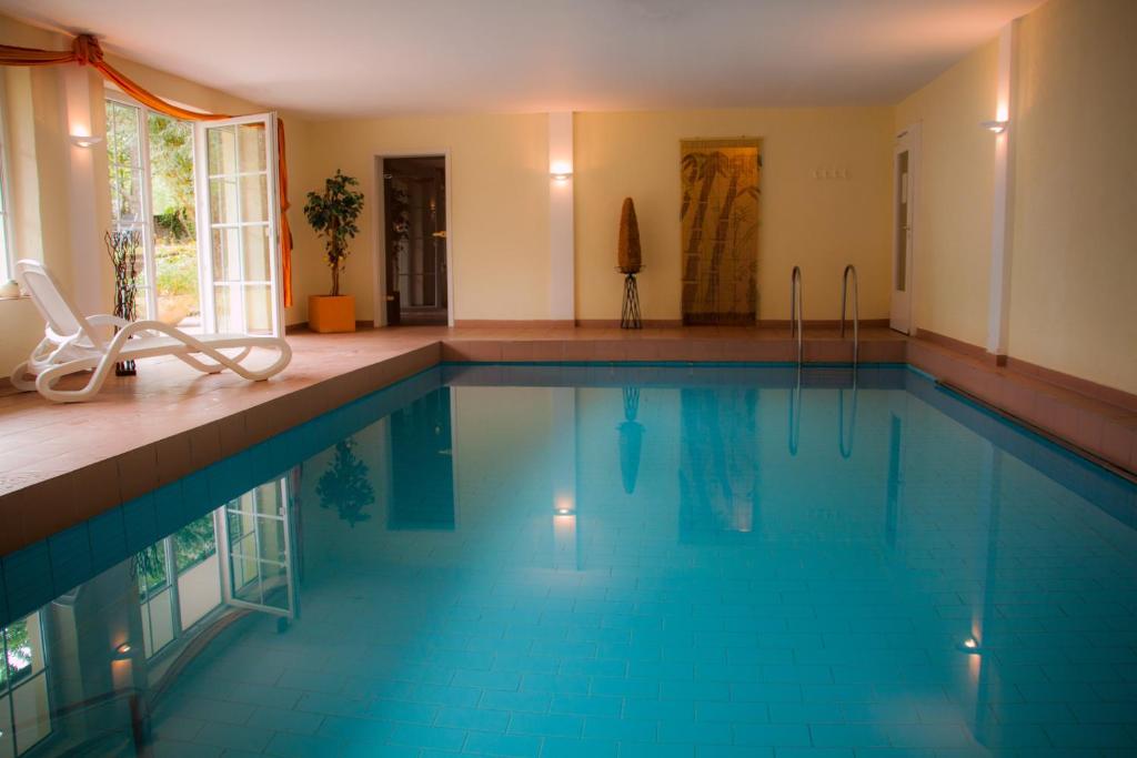a swimming pool with blue water in a house at Hotel Landhaus Waldesruh in Freudenstadt