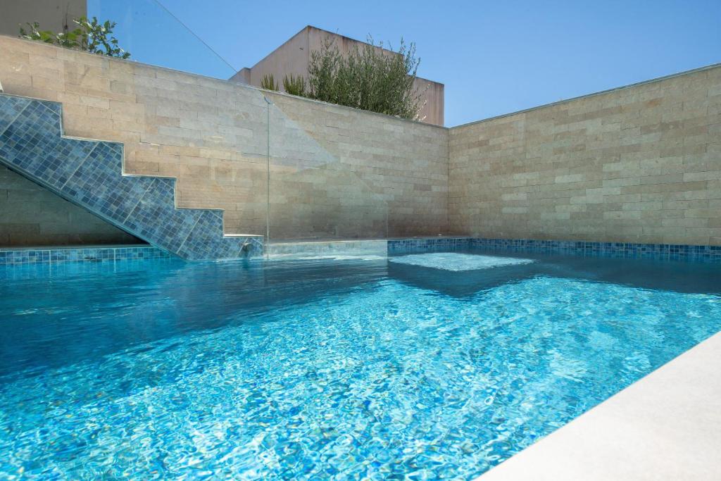a swimming pool in a house with a brick wall at Santa Marina Luxury Apartments #1 with pool in Asgourou