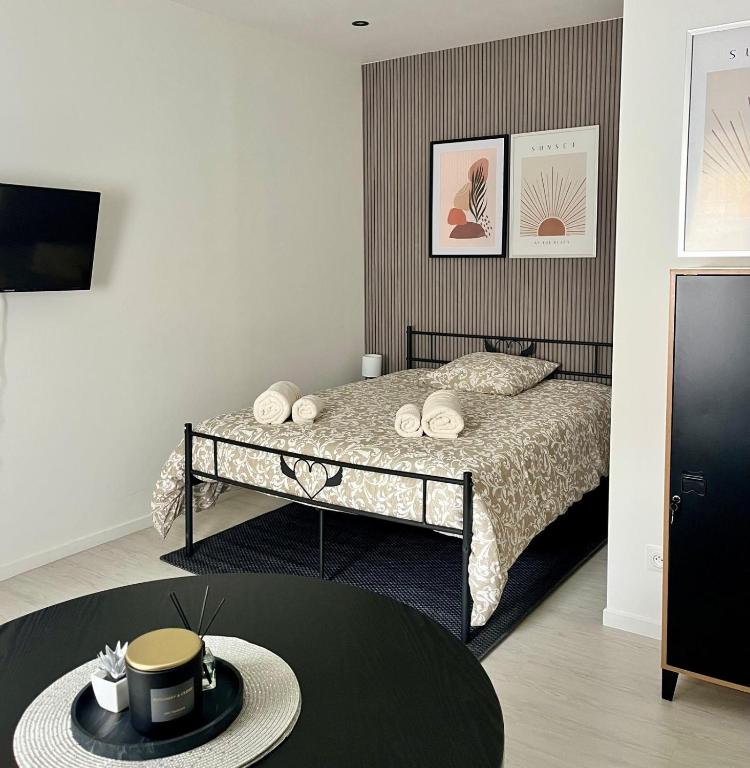 - une chambre avec un lit et une table avec un chapeau dans l'établissement Paul Bert-2 studio avec extérieur privatif, à Cambrai