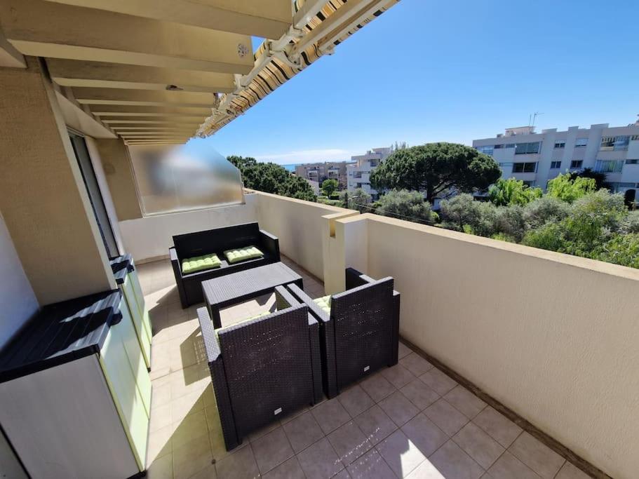 - un balcon avec deux tables et des chaises dans un bâtiment dans l'établissement Cozy 1 Br with a seaview, AC, Pool and Parking, à Antibes
