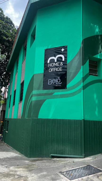a green building with a sign on the side of it at Belô Home & Office in Belo Horizonte
