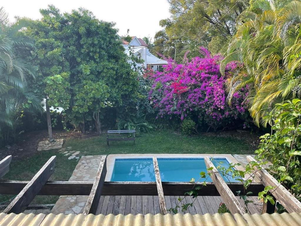 - une piscine dans un jardin fleuri dans l'établissement Villa Los Cerros, hermosa villa familiar, colina en el bosque y la playa, à La Pared