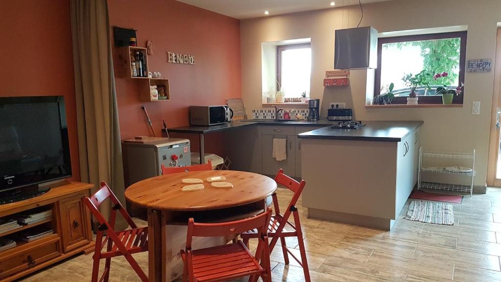 une cuisine avec une table et des chaises et une télévision dans l'établissement Calme et tranquillité entre Annecy et Genève, à Vovray-en-Bornes