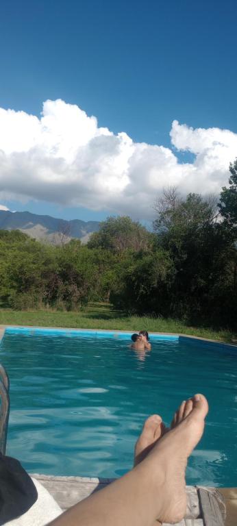 a person with their feet in a swimming pool at Casa Del Valle Traslasierra in Las Chacras (La Paz)