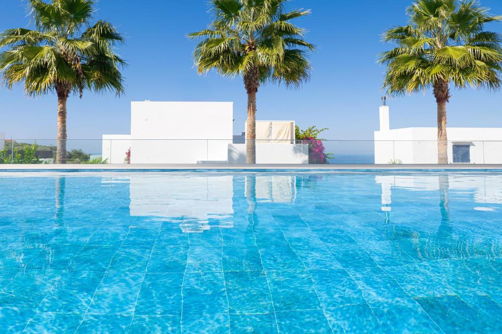 a swimming pool with palm trees in the background at Stefania Panoramic Views Peaceful Getaway Crete in Maroulás