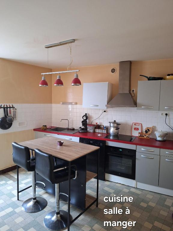 une cuisine avec une table en bois au milieu dans l'établissement Gîte 6 personnes, à La Souterraine