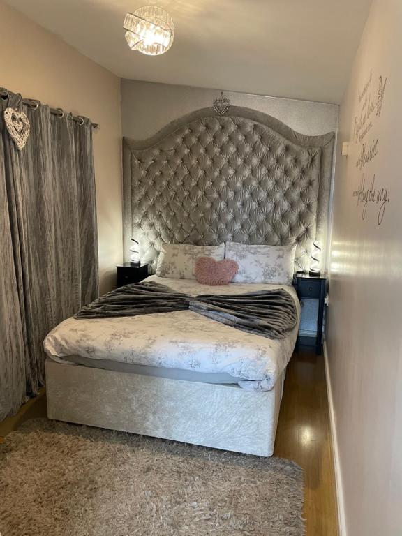 a bedroom with a large bed with a large headboard at Cleomack View, Annexe apartment with Hot Tub in Hilltown