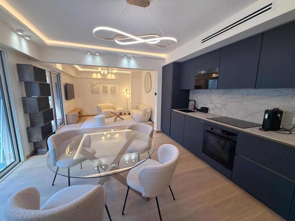 une cuisine avec une table en verre et des chaises blanches dans l'établissement Luxury 2 chambres Center of Cannes - Croisette, à Cannes