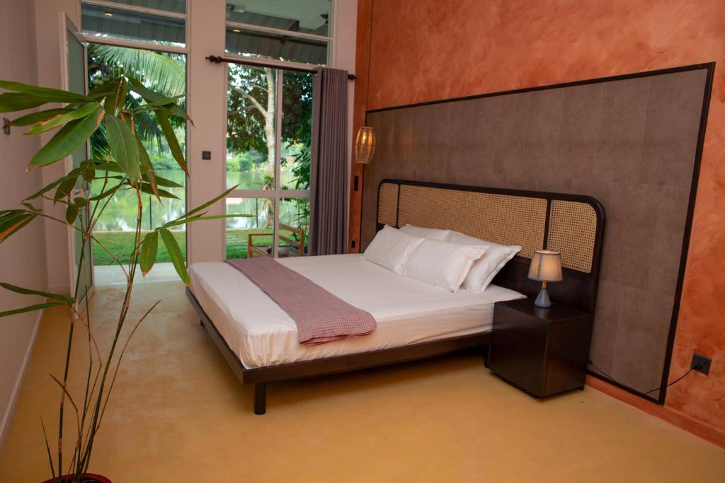 Un dormitorio con una cama y una ventana grande en Villa Sansun - Riverside Escape, en Weligama