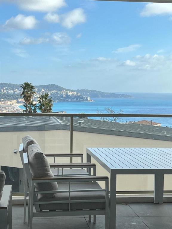 une table et des chaises sur un balcon avec vue sur l'océan dans l'établissement Appartement d'exception vue mer Nice Blue Pearl, à Nice