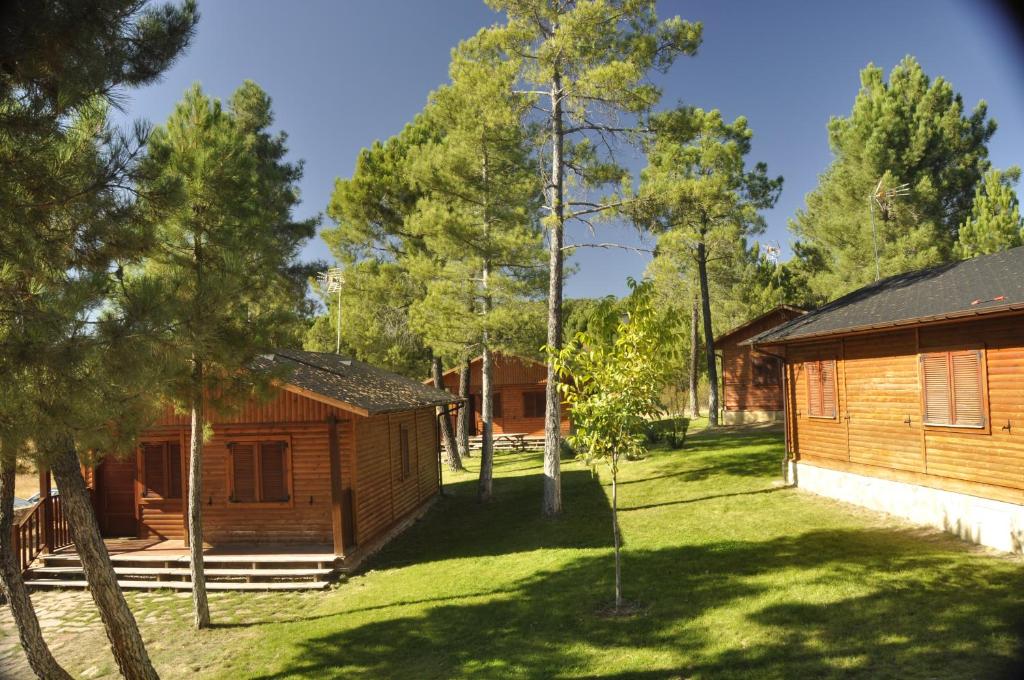 una cabaña de madera en un patio con árboles en Cabañas Rurales Los Barrancos en Villalba de la Sierra