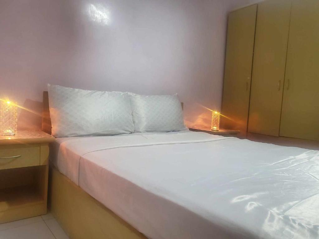 à 10 minutes du grand mall d'Afrique, WiFi Netflix 1ère étage في Oulad Hamida: غرفة نوم بسرير ابيض وعليها انوار