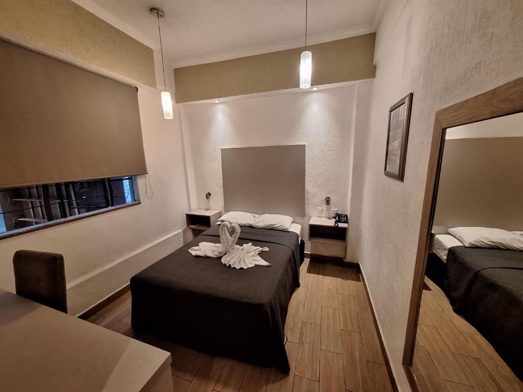 a hotel room with two beds and a mirror at Hotel Palace Puebla in Puebla