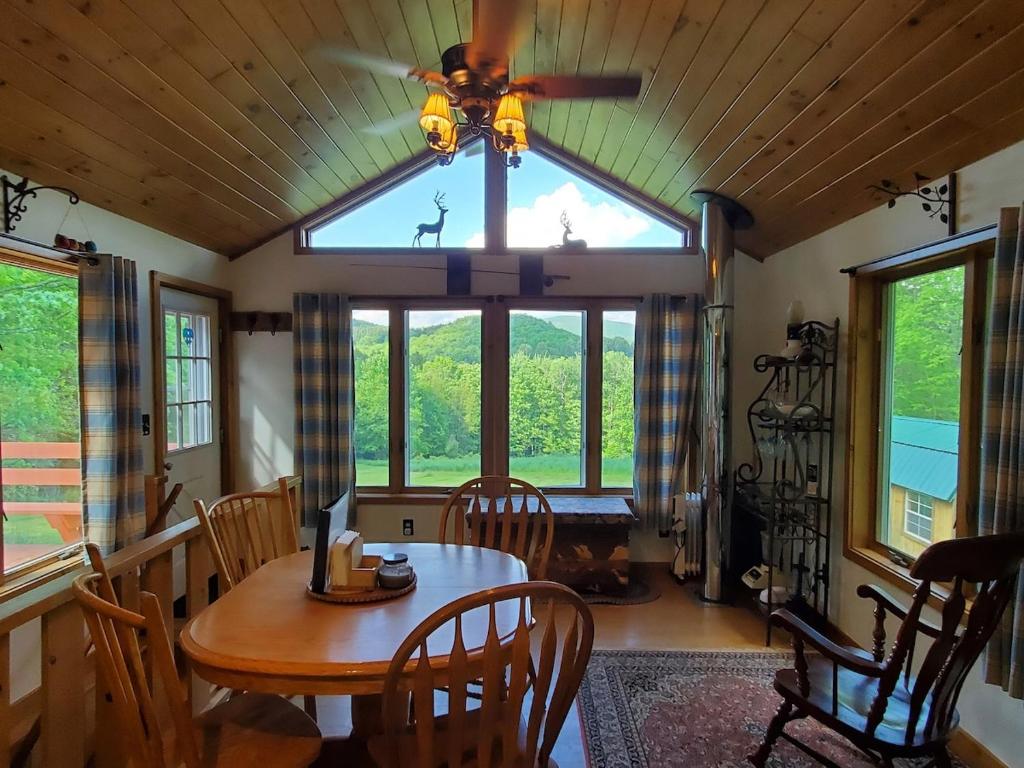 a dining room with a table and a ceiling fan at Pleasant Brook Cottage in Roxbury