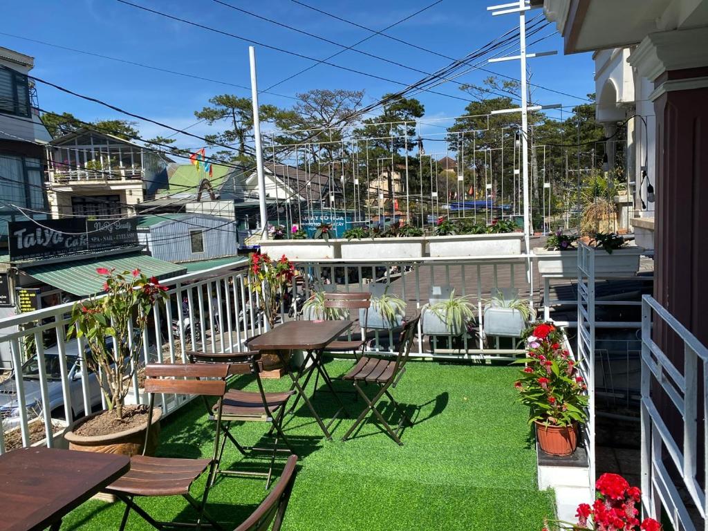 a patio with tables and chairs on a balcony at Chất home in Da Lat