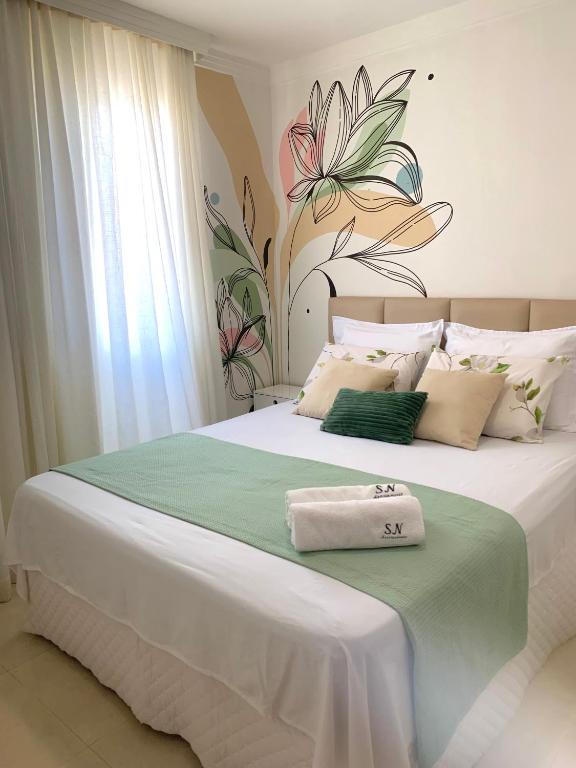 a bedroom with a large bed with two towels on it at Apartamento SN Orlando Dantas in Aracaju