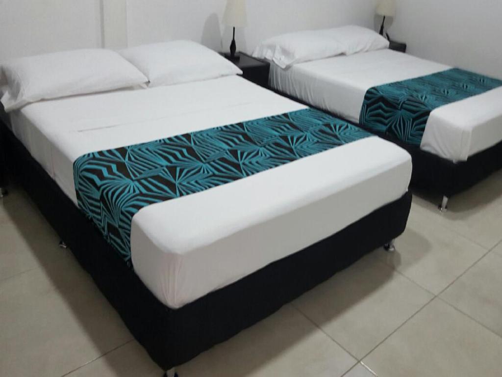 2 łóżka pojedyncze w pokoju z: w obiekcie Hotel Septima Avenida w mieście Neiva