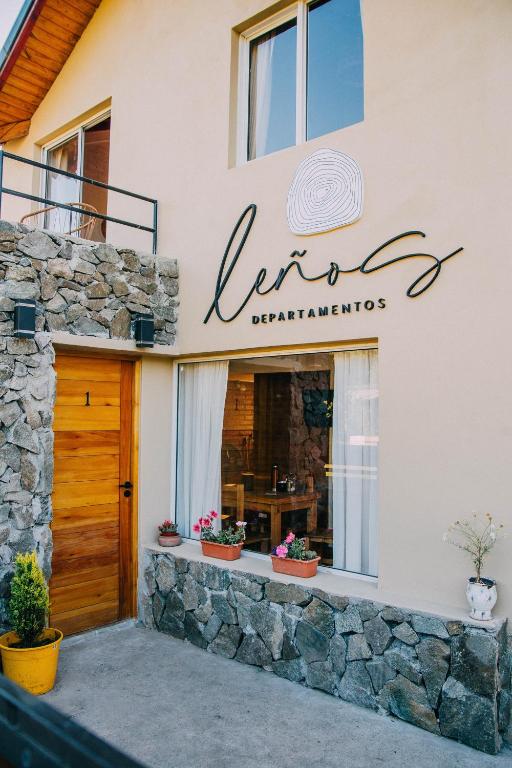 a building with a sign for a restaurant at Leños departamentos in El Bolsón