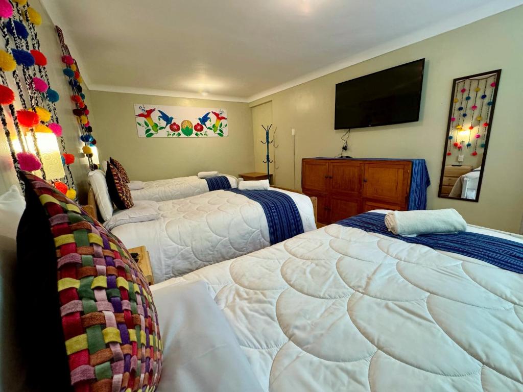 a bedroom with two beds and a flat screen tv at Tika house in Cusco