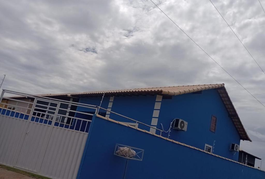 a blue building with a gate and a sky at Horizonte Azul in Cabo Frio