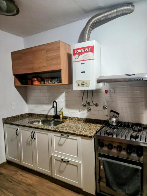 een keuken met een fornuis en een spoelbak bij Casita Verde in Rosario