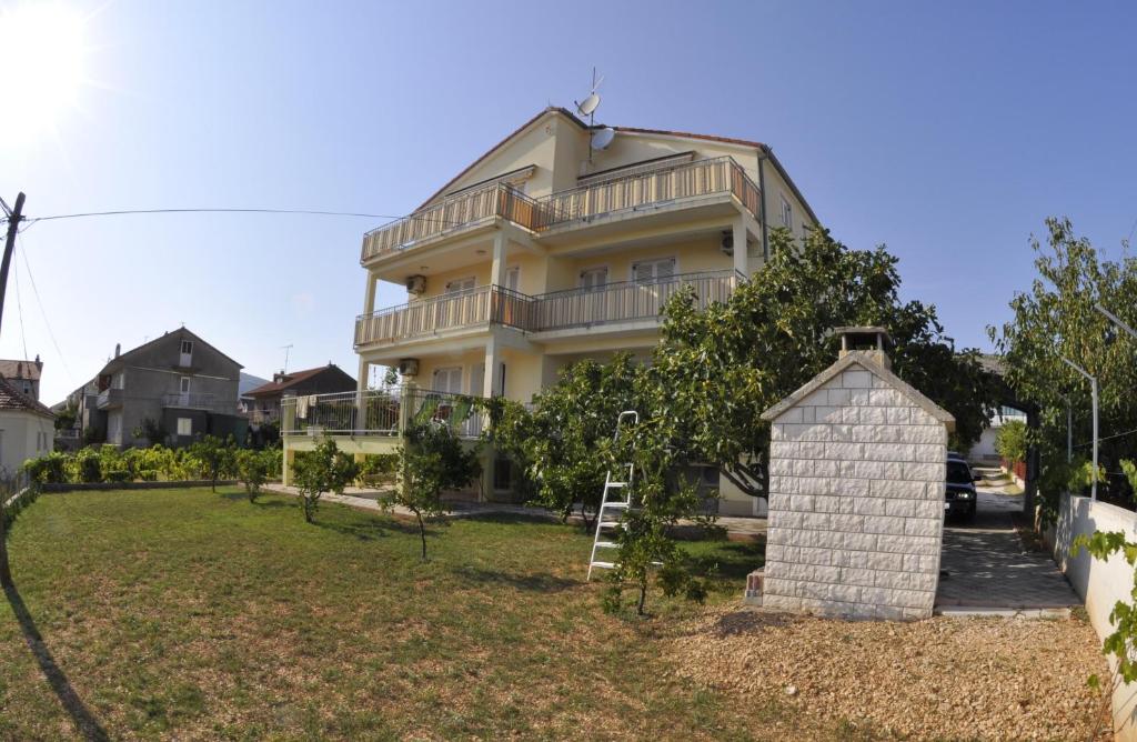 een groot huis met een tuin ervoor bij Apartments Trogir in Trogir
