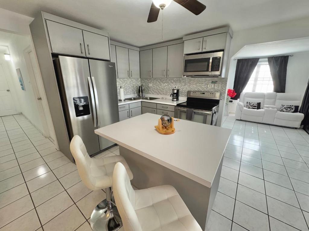 a kitchen with a white counter and chairs in it at Vacation Rental Ceiba PR B16 in Ceiba
