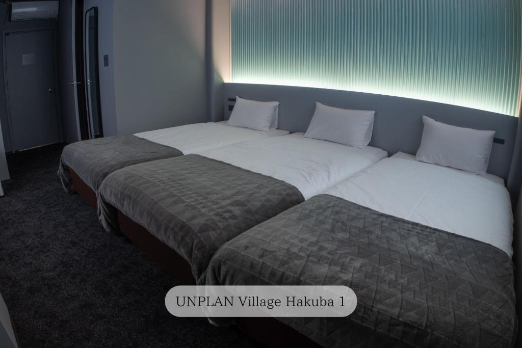 Postel nebo postele na pokoji v ubytování UNPLAN Village Hakuba
