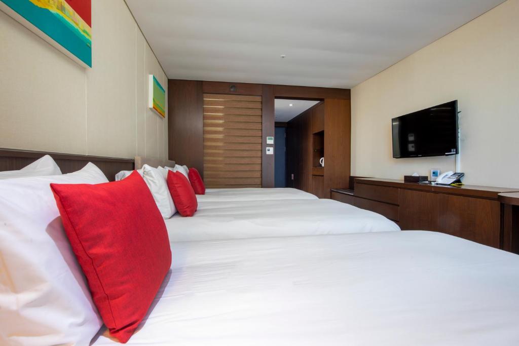 Postel nebo postele na pokoji v ubytování Ramada by Wyndham Jeju Hamdeok