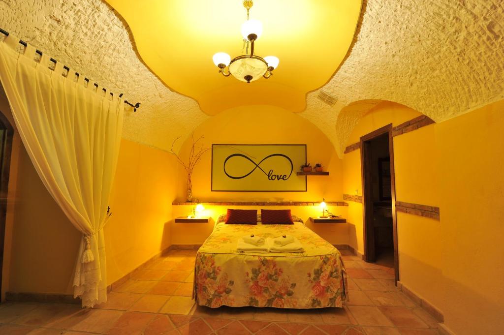 een slaapkamer met een bed in een gele kamer bij Cuevas La Granja in Benalúa de Guadix