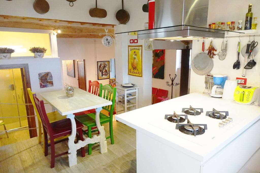 een keuken met een wit aanrecht en een tafel bij Palazzo Colombi in Montepulciano