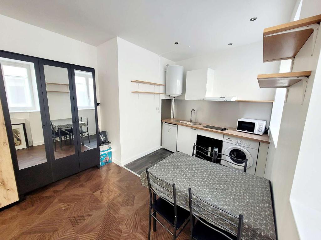 - une petite cuisine avec une table, une table et une cuisinière dans l'établissement Studio de charme avec Wifi en centre-ville - FR-1-675-45, à Boulogne-sur-Mer