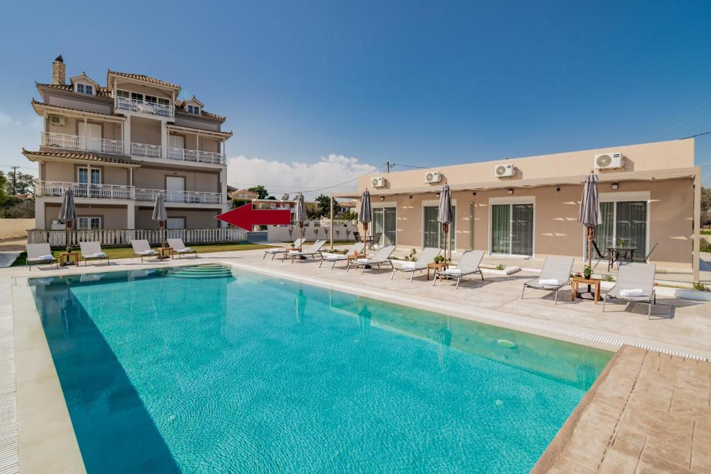 a swimming pool with chairs and a building at Cinque Terre Gardenia in Zakynthos