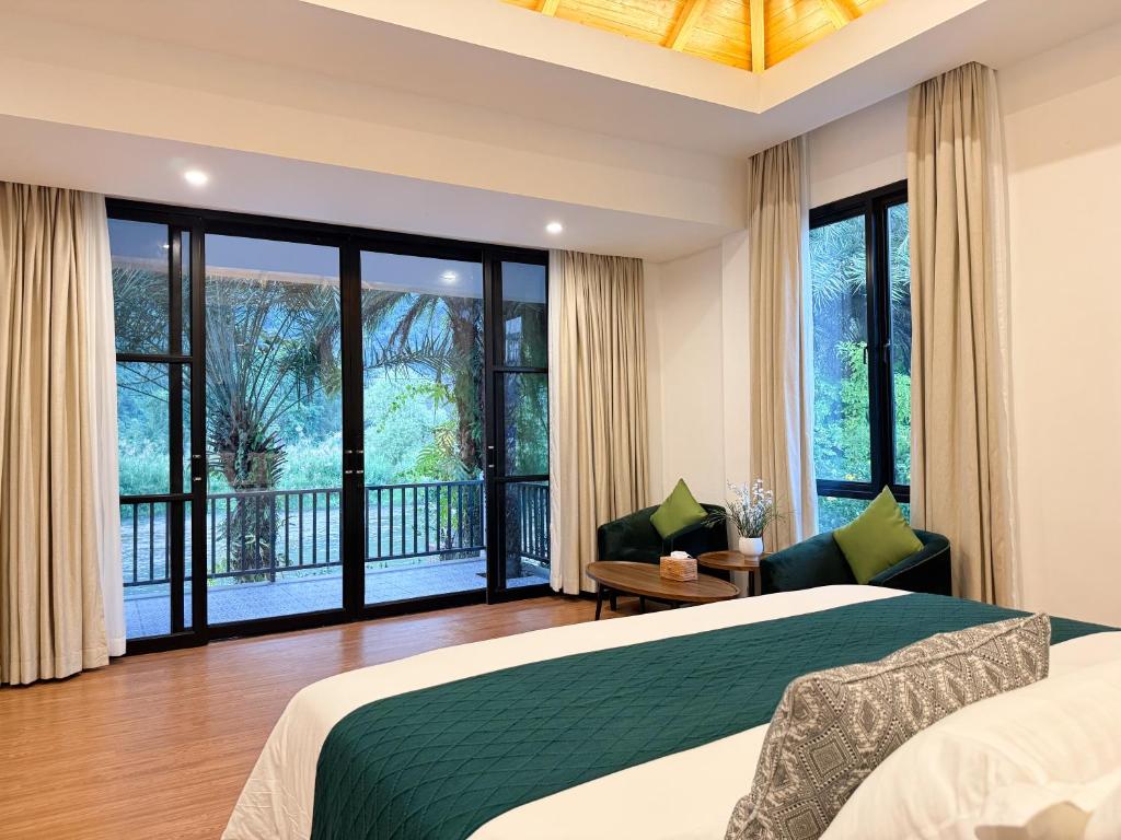 una camera da letto con un letto grande e un balcone di Phalai view hotel a Vang Vieng