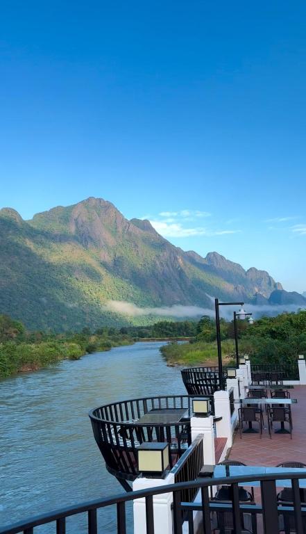 una vista di un fiume con tavoli e sedie di Phalai view hotel a Vang Vieng