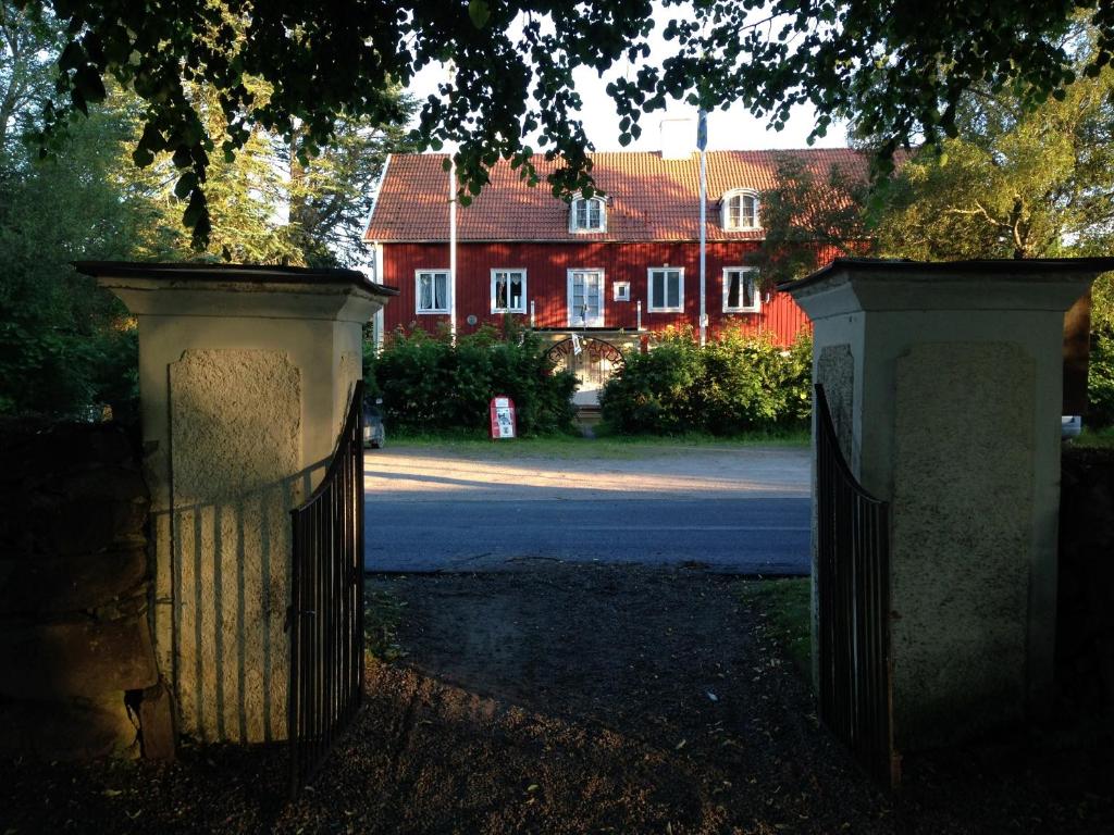 a gate in front of a house with a building in the background at STF Regnagården Hostel in Regna