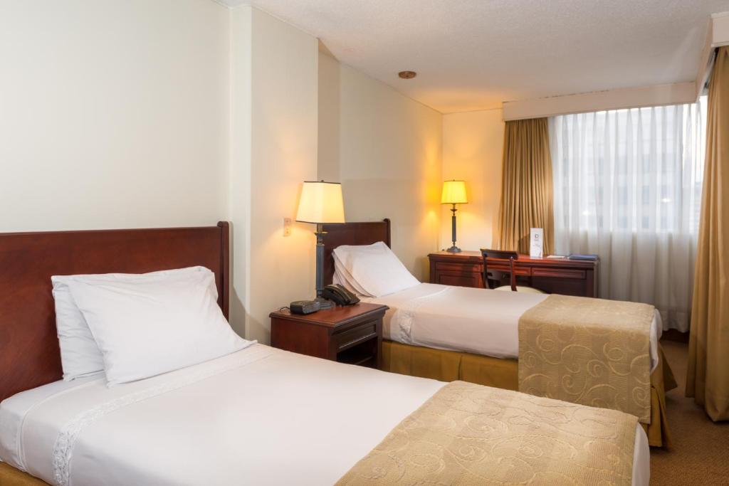 Postel nebo postele na pokoji v ubytování Hotel Dann Av. 19