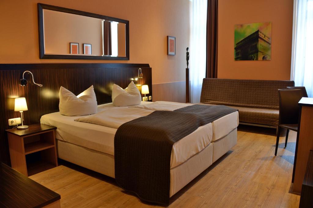 ein Hotelzimmer mit einem großen Bett und einem Sofa in der Unterkunft Arthotel Munich in München