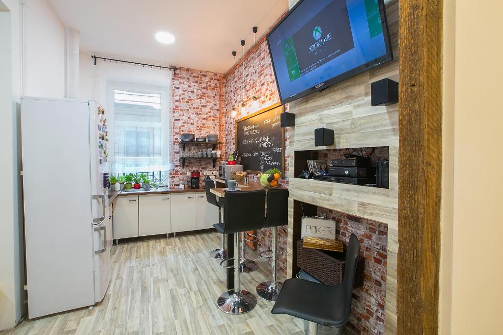 Il comprend une cuisine avec un bar et une télévision murale. dans l'établissement Friends Hostel & Apartments, à Budapest