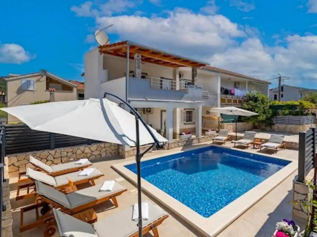 a villa with a swimming pool and patio furniture at Vacation home Marin in Vinišće