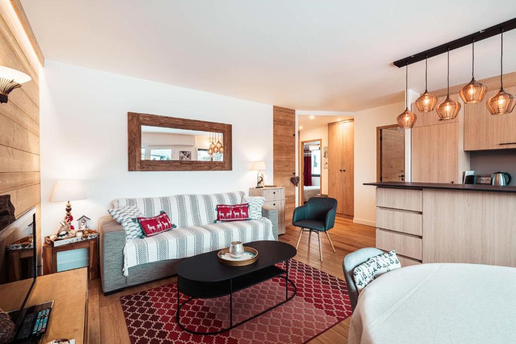 un salon avec un canapé et une cuisine dans l'établissement Chamois Blanc - Ideal for families, à Megève