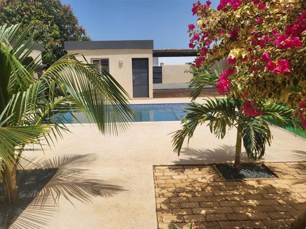 a house with a swimming pool and some flowers at Villa luxueuse à ngaparou saly center in Ngaparou