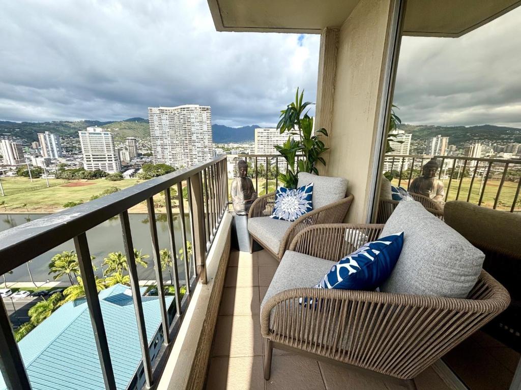 a balcony with chairs and a view of the city at Honu Hideaway Studio at Royal Garden in Honolulu