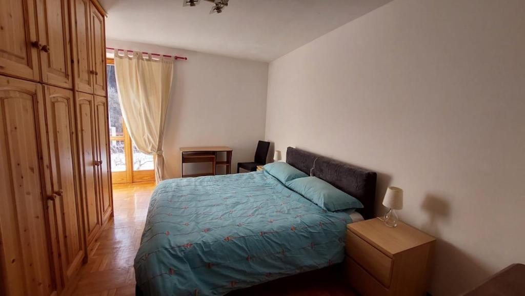 a bedroom with a bed with a blue comforter at LinHaus in Limone Piemonte