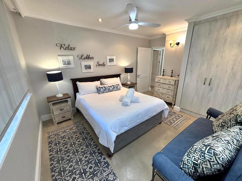 ein Schlafzimmer mit einem großen Bett und einer blauen Couch in der Unterkunft Low tide at no 35 in St Francis Bay