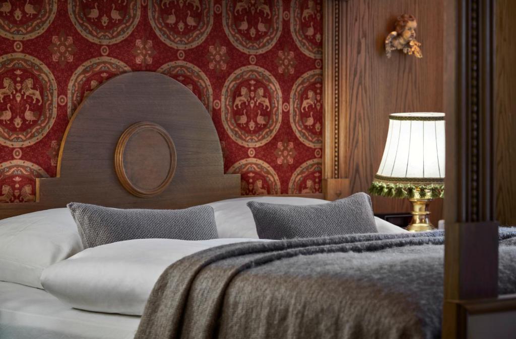 a bedroom with a bed and a red wall at Hotel Goldener Greif in Kitzbühel