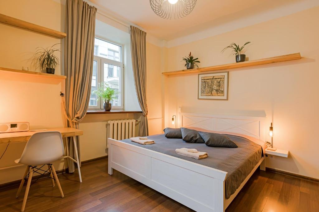 Un dormitorio con una cama grande y un escritorio. en Cozy studio and standard apartments in the heart of Oldtown, en Vilna