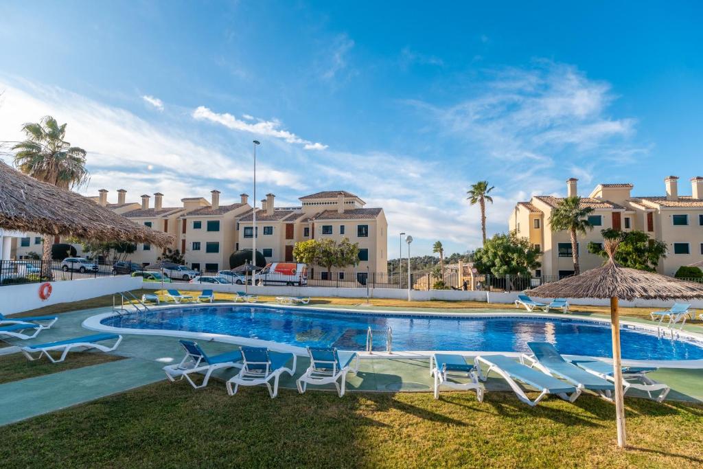 a large swimming pool with chairs and umbrellas at Casa Del Alba Golf in Alicante