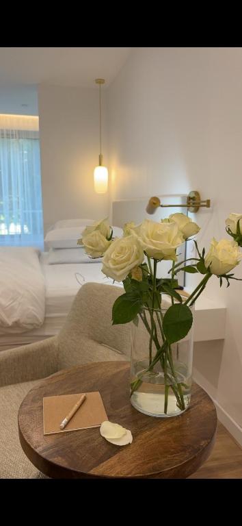 un vase avec des roses jaunes sur une table dans le salon dans l'établissement Le cap dagde, au Cap d'Agde